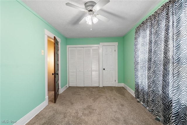 unfurnished bedroom with light colored carpet, ceiling fan, a textured ceiling, and a closet