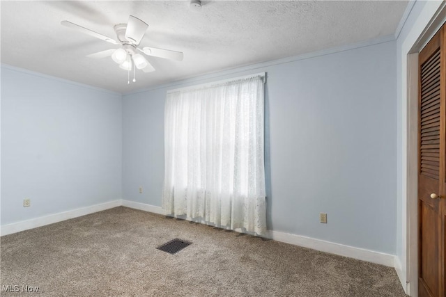 spare room featuring ornamental molding, a textured ceiling, carpet floors, and ceiling fan