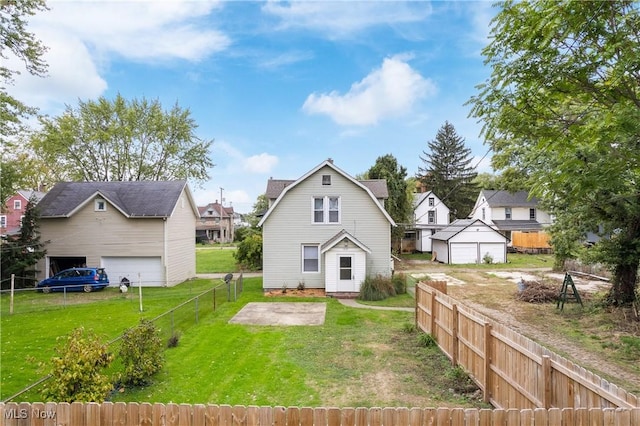 back of house featuring a yard, an outbuilding, and a garage