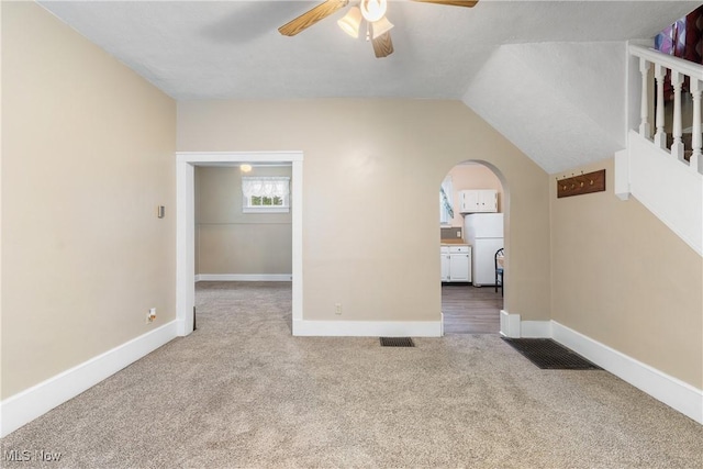 empty room featuring carpet flooring, ceiling fan, and vaulted ceiling