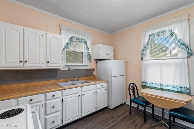 kitchen with white appliances, white cabinetry, a wealth of natural light, and sink