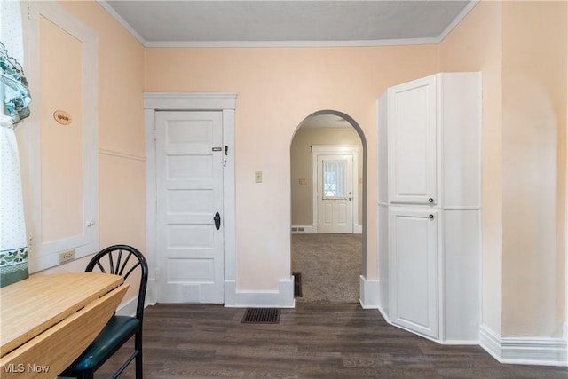 dining space with crown molding and dark wood-type flooring