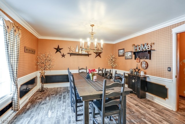 dining space with a notable chandelier, crown molding, and hardwood / wood-style floors