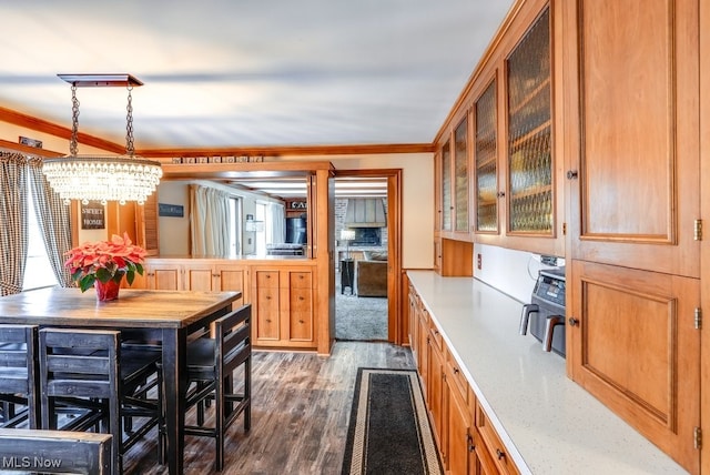 kitchen with an inviting chandelier, ornamental molding, hanging light fixtures, and dark hardwood / wood-style floors