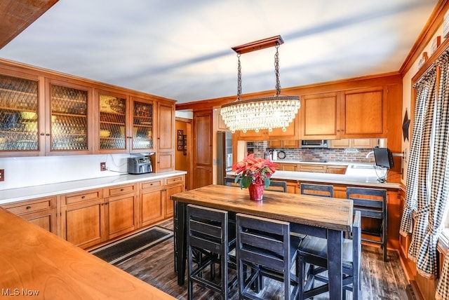 kitchen featuring decorative light fixtures, wood counters, decorative backsplash, a chandelier, and dark wood-type flooring