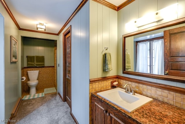 bathroom featuring toilet, ornamental molding, and vanity