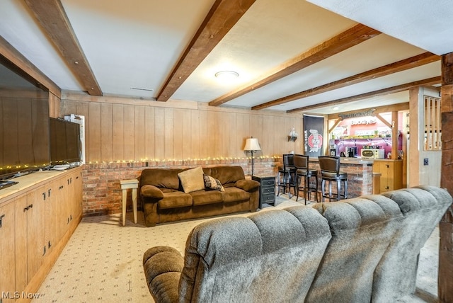 living room featuring beam ceiling, indoor bar, and wood walls