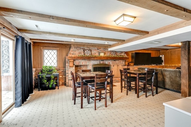 dining space featuring light colored carpet, plenty of natural light, and beam ceiling