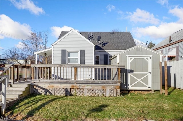 rear view of house featuring a lawn, a storage unit, and a wooden deck