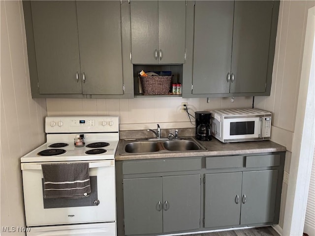 kitchen featuring white appliances, gray cabinets, and sink