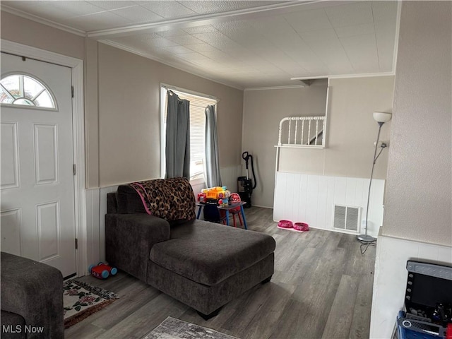 living room featuring hardwood / wood-style flooring, crown molding, and heating unit