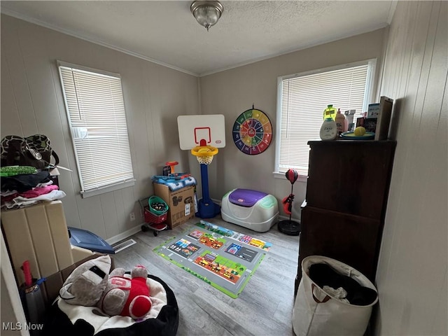 rec room with wood-type flooring, wood walls, and crown molding