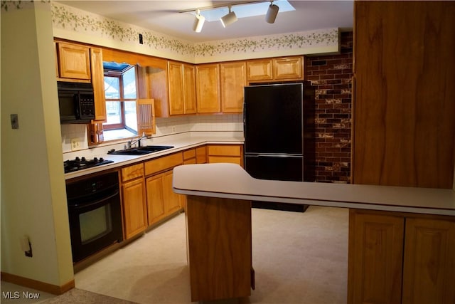 kitchen with black appliances, sink, light carpet, and a breakfast bar area