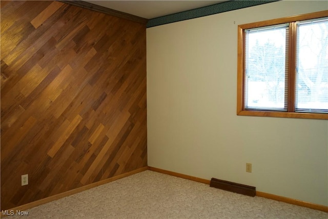 unfurnished room with ornamental molding and carpet