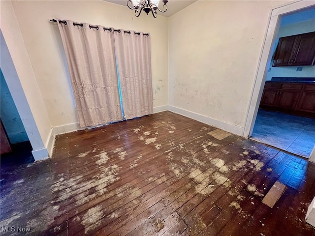 unfurnished dining area with dark hardwood / wood-style flooring and a chandelier