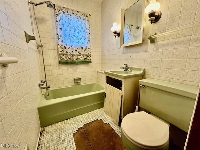 full bathroom featuring washtub / shower combination, toilet, vanity, tile patterned floors, and tile walls