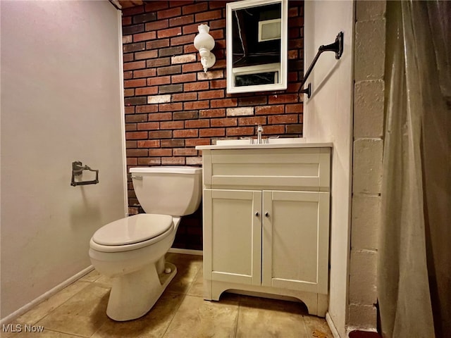 bathroom with vanity, brick wall, and toilet