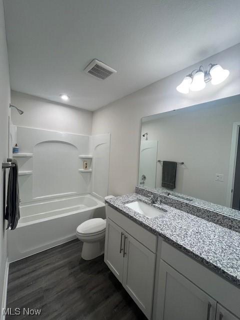 full bathroom with toilet, hardwood / wood-style flooring, shower / bathtub combination, and vanity