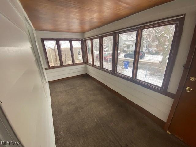 unfurnished sunroom with wood ceiling