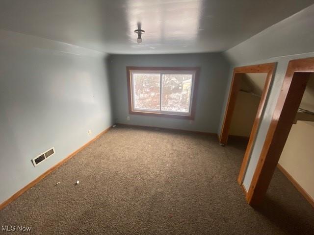 bonus room with carpet floors and vaulted ceiling