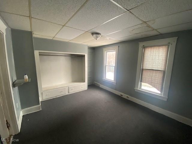 unfurnished bedroom featuring a paneled ceiling and a closet