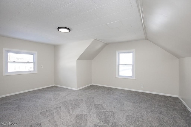 bonus room with vaulted ceiling and carpet