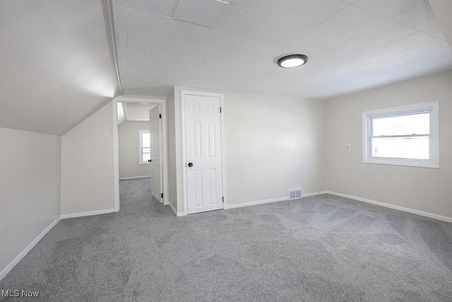 bonus room with carpet floors and vaulted ceiling