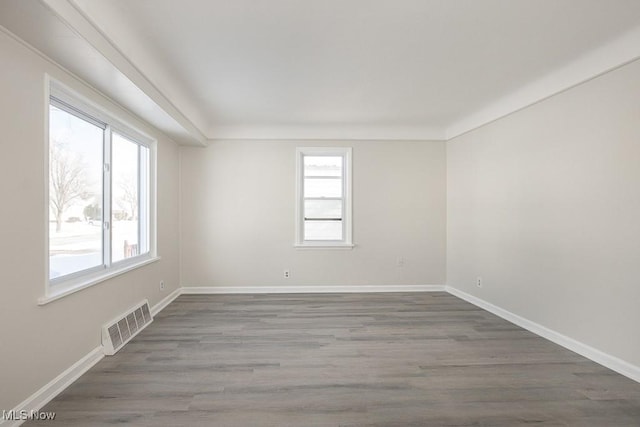 unfurnished room with plenty of natural light and dark hardwood / wood-style floors