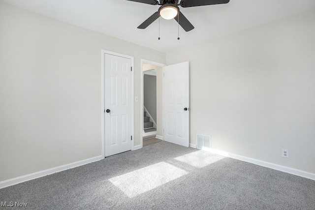 empty room with ceiling fan and carpet floors