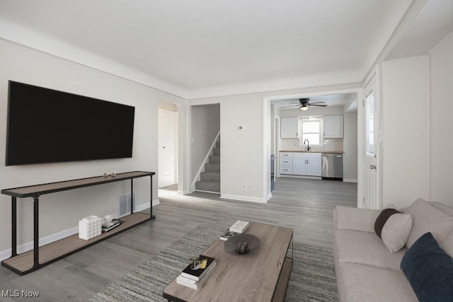 living room with ceiling fan, sink, and hardwood / wood-style floors