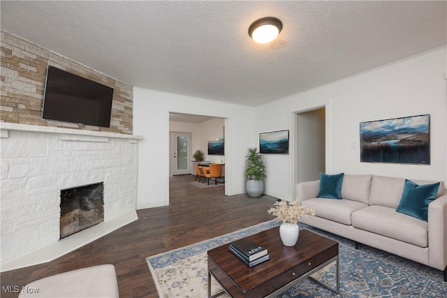 living room featuring dark hardwood / wood-style flooring, a fireplace, and a textured ceiling