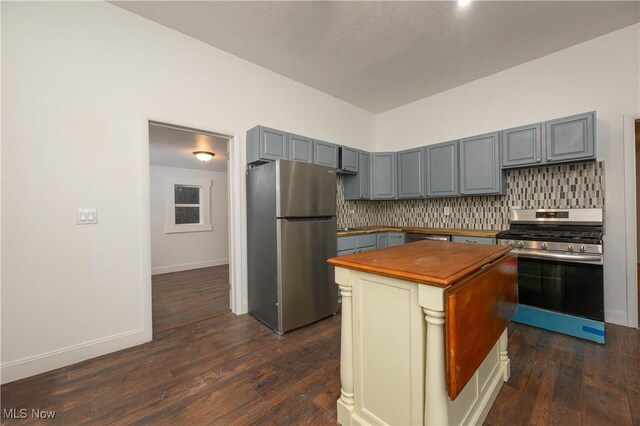 kitchen with stainless steel appliances, backsplash, and dark hardwood / wood-style flooring