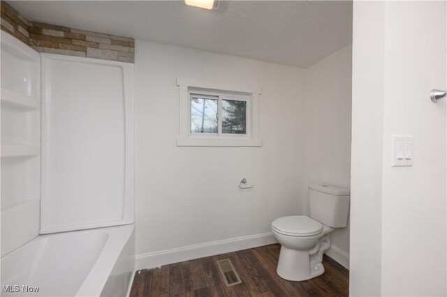 bathroom featuring hardwood / wood-style flooring, shower with separate bathtub, and toilet