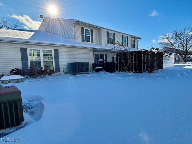 snow covered back of property with central AC