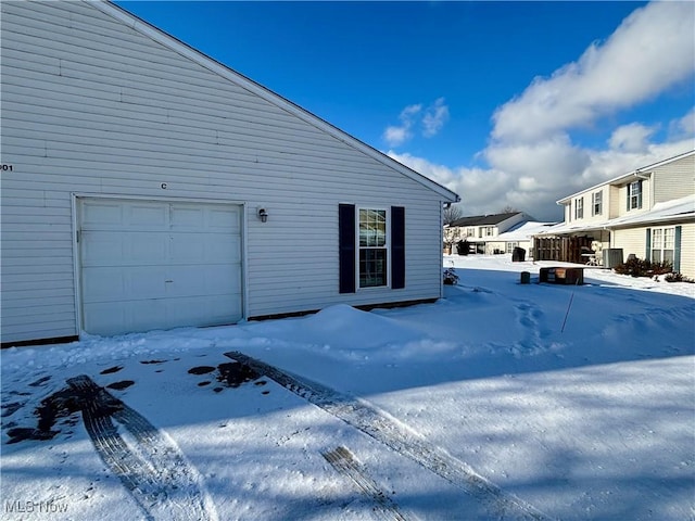 view of snowy exterior featuring a garage