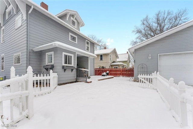 snow covered house with a garage