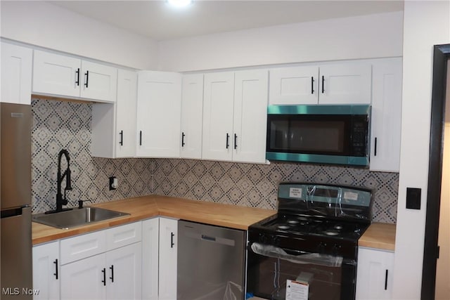 kitchen featuring tasteful backsplash, butcher block counters, appliances with stainless steel finishes, and white cabinetry