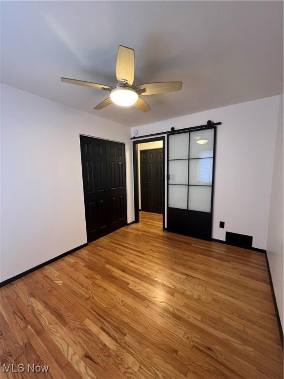 unfurnished bedroom with ceiling fan, light hardwood / wood-style flooring, and a closet