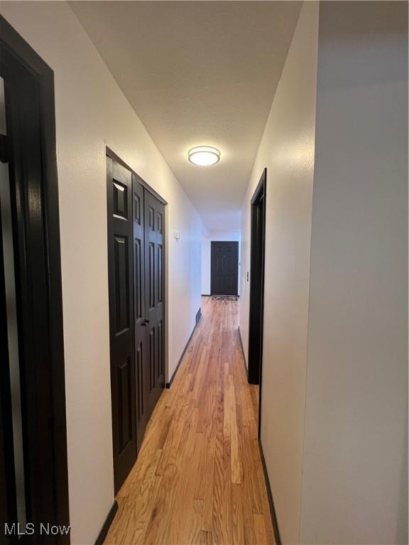 hallway with light hardwood / wood-style floors