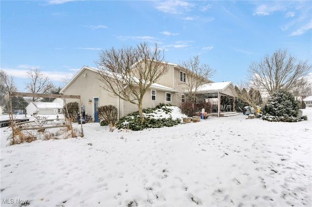 view of snow covered back of property