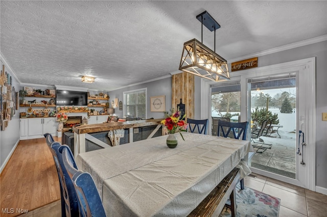 dining space with ornamental molding, a textured ceiling, and light tile patterned floors