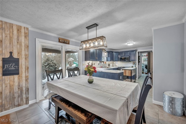 dining space featuring light tile patterned floors, a textured ceiling, ornamental molding, and a healthy amount of sunlight