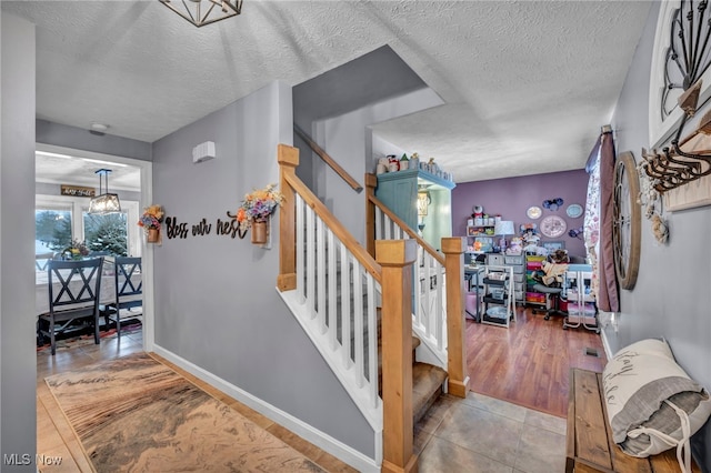 stairs featuring a textured ceiling and tile patterned flooring