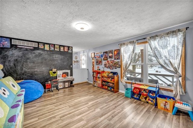 game room with a textured ceiling and hardwood / wood-style floors