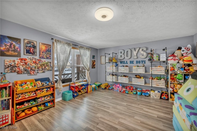 playroom with hardwood / wood-style flooring and a textured ceiling