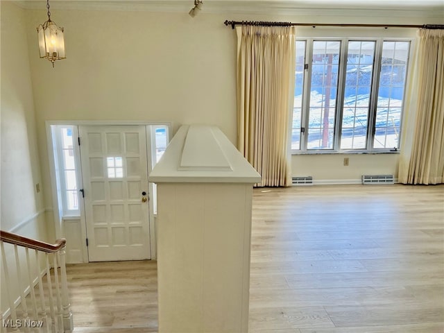 foyer entrance featuring light hardwood / wood-style flooring and a chandelier