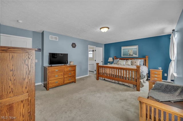 bedroom featuring a textured ceiling and light carpet