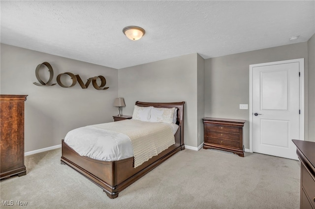 bedroom with a textured ceiling and light colored carpet