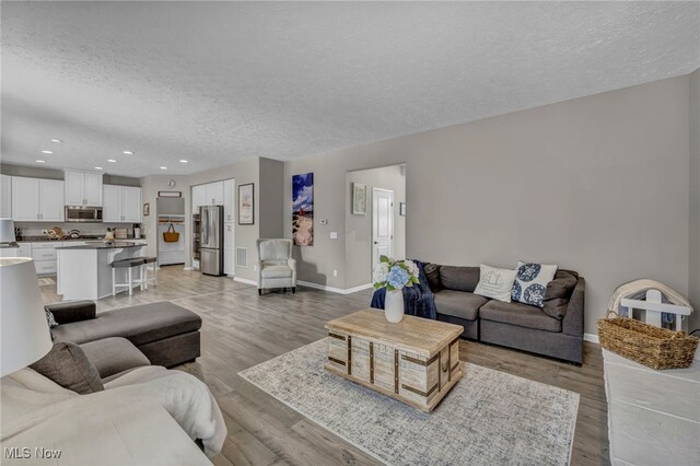 living room featuring a textured ceiling and light hardwood / wood-style flooring