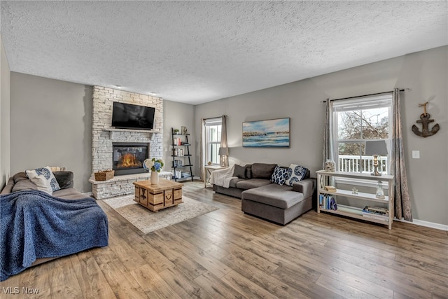 living room featuring hardwood / wood-style floors, a textured ceiling, and a fireplace